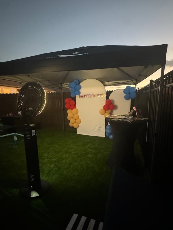 Professional photo booth setup with LED ring light, tent, and backdrop at dusk