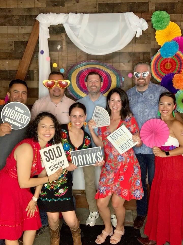 Happy group at a corporate event with colorful props and signs